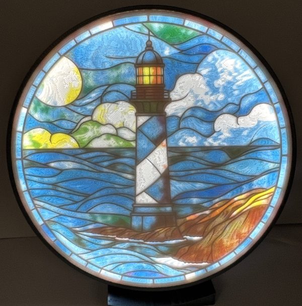 Nautical lighthouse lithophane lamp emitting soft light, showcasing colorful stained-glass style artwork.