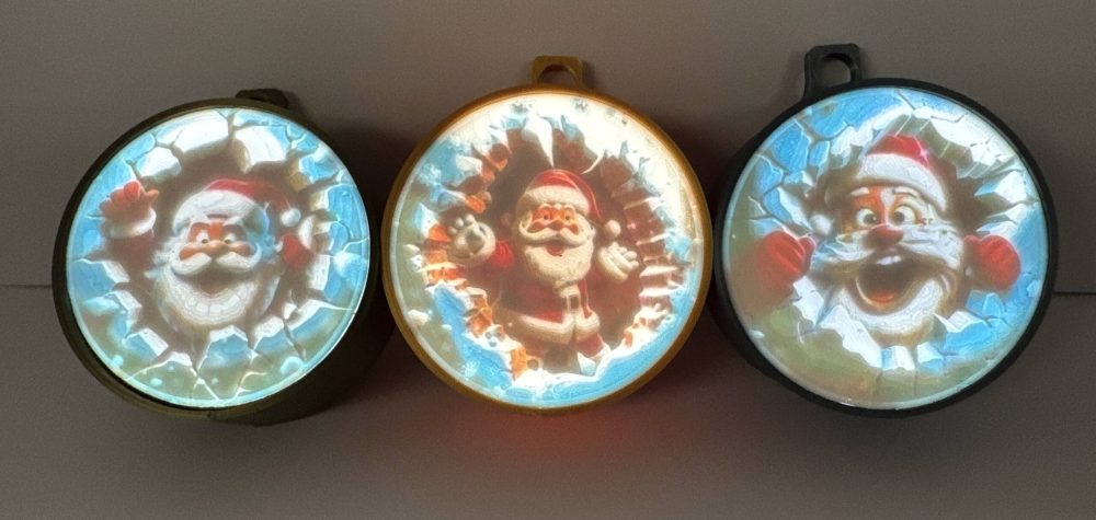 Set of three lighted Santa Claus ornaments in blue, yellow, and red, battery operated.